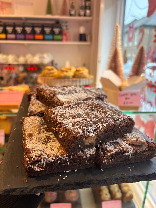 Chocolate brownies topped with coconut flakes, box of four slices
