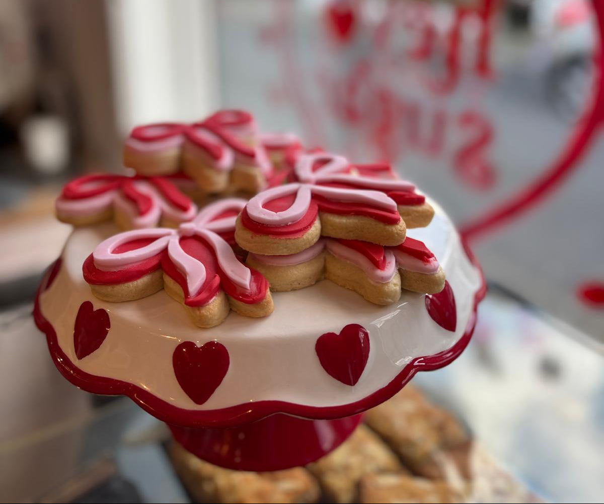 Hand-iced Valentine’s biscuits displayed on a heart cake stand at Marley’s Bakery