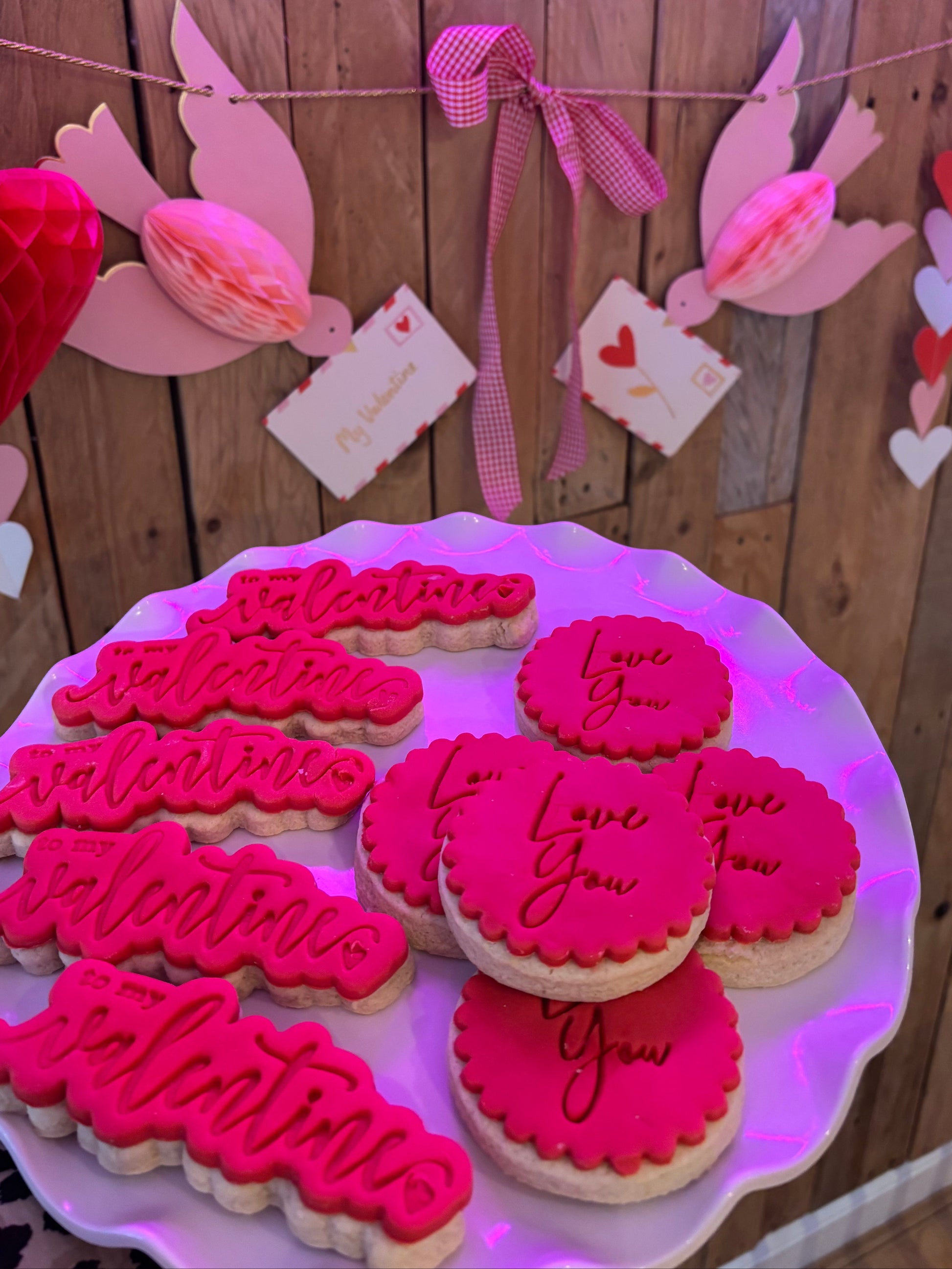 Handmade Valentine’s iced biscuits with pink icing and love message designs